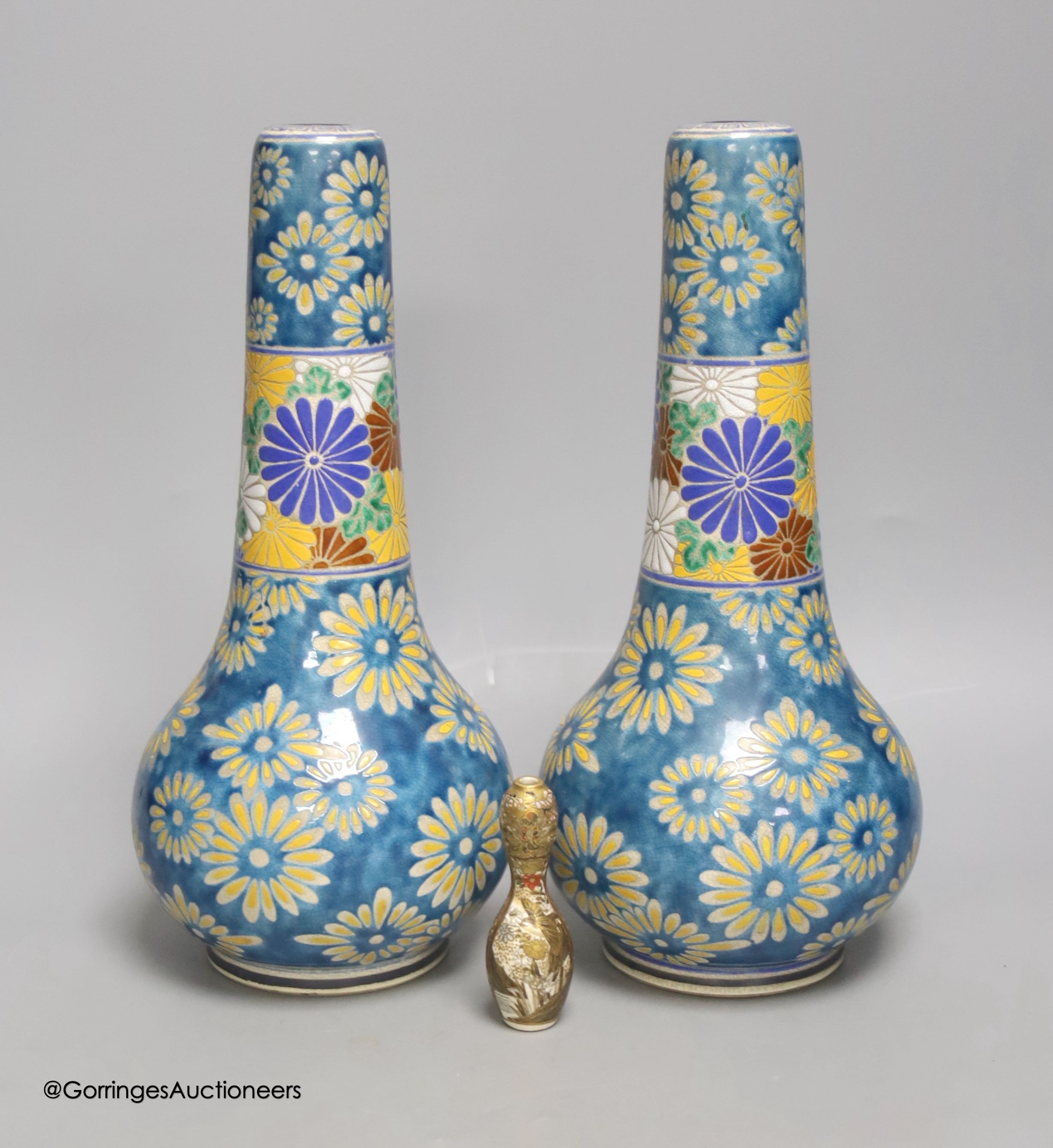 A pair of Japanese Satsuma pottery bottle vases by Taizan Yohei IX, 30cm and a miniature Satsuma vase